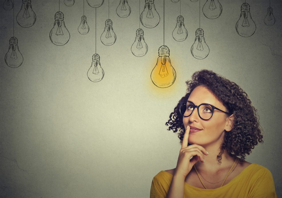 thinking woman in glasses looking up with light idea bulb above head